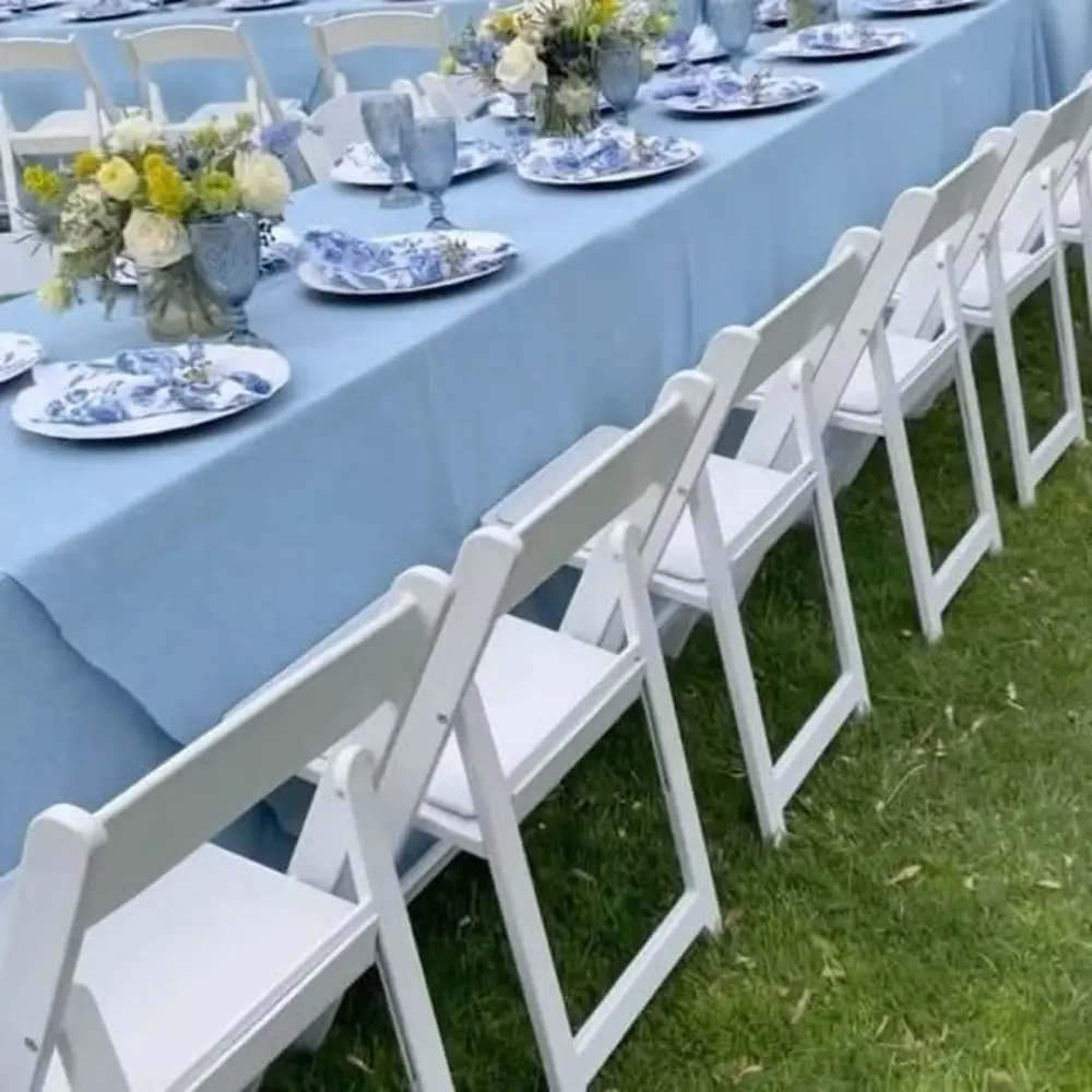 Blue linen table with white folding chairs
